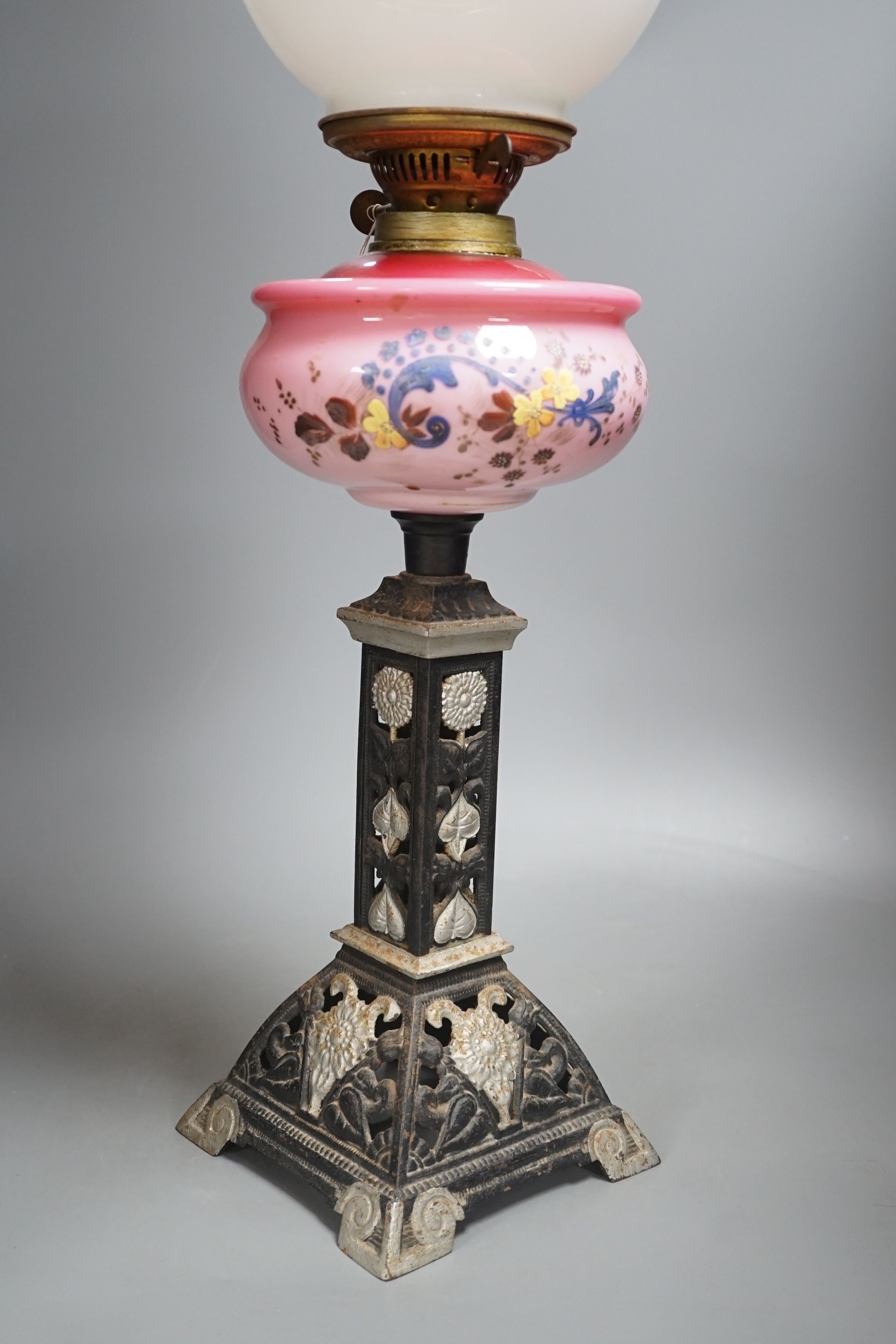 A Victorian cast iron and enamelled glass oil lamp